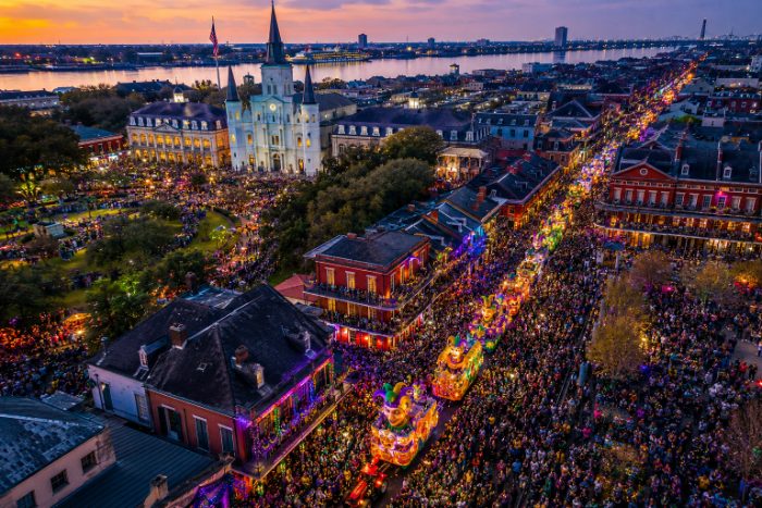 Parade floats rolling past the cathedral at dusk