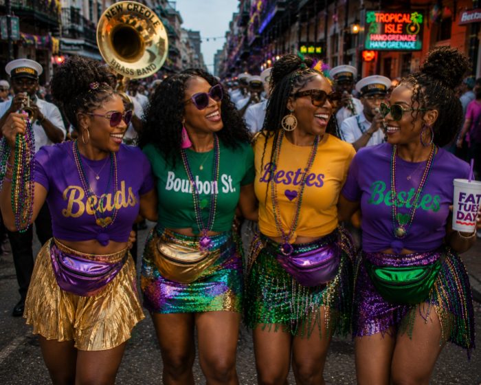 Friends in matching tees and beads on the parade route